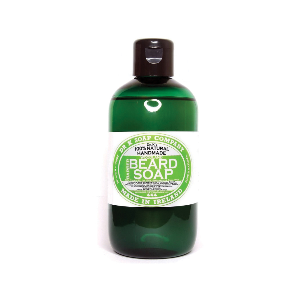 dr-k-barber-beard-soap-woodland-250ml Bottiglia verde di sapone per la barba con etichetta circolare bianca e tappo scuro